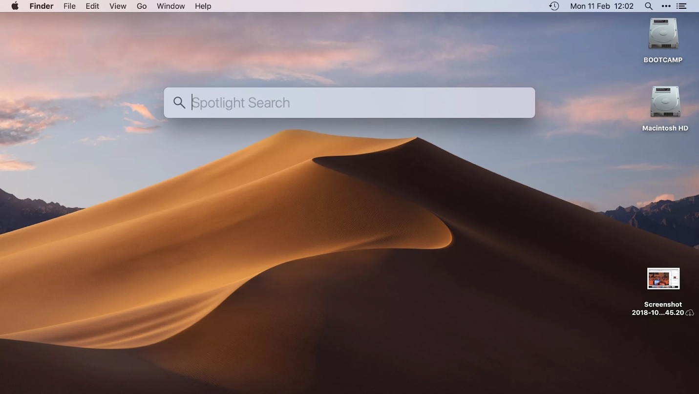 macOS desktop showing empty Spotlight search window